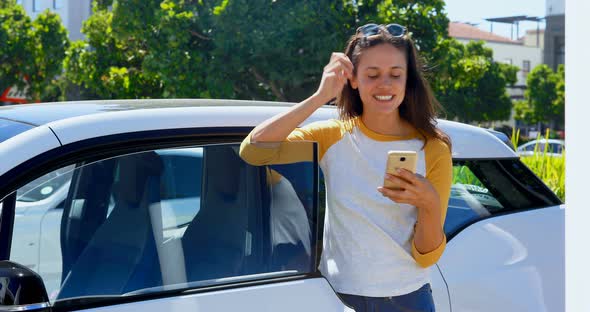 Woman using mobile phone near her car 4k