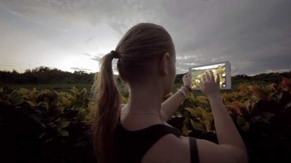 Woman Outdoor Using Tablet PC To Make Photos