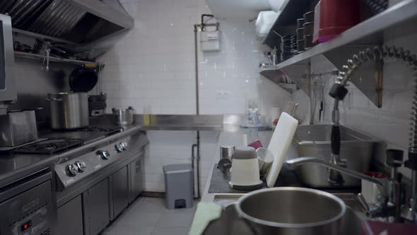 Pushout of Metal Restaurant Kitchen with Appliances and Dirty Dishes