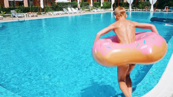 Man Jumping in Swimming Pool at Sunny Day. alt