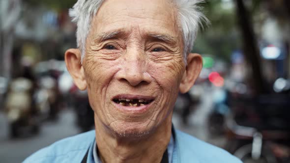 Handheld video shows of Vietnamese senior man looking at camera. Shot with RED helium camera in 8K