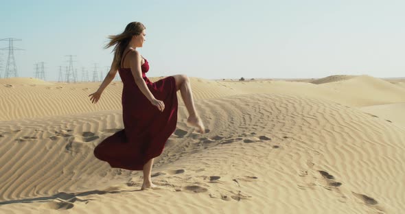 Vacation in Dubai Young Lady in Red Dress is Dancing in the Desert