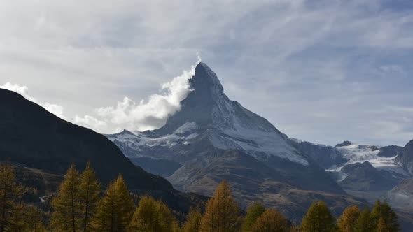 Picturesque View of Matterhorn Peak and and Orange Autumn Forest in Swiss Alps
