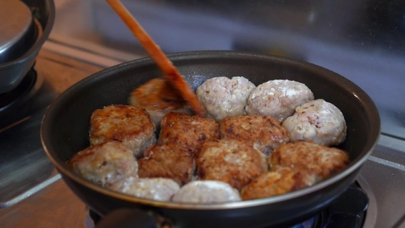 Female Hands Turning Meatballs In a Pan