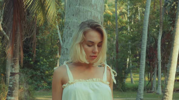Young Blonde Standing Contemplating Tropical Rainforest Sunset Light Coming From Above
