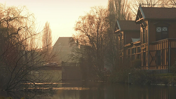 People Cross Bridge Over Canal At Sunset