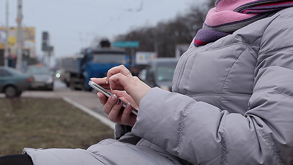 Woman Using Her Smartphone Sitting In Outdoor