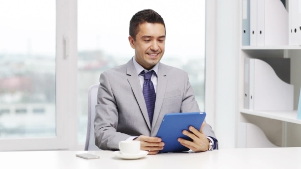 Smiling Businessman With Tablet Pc And Coffee Cup