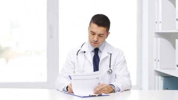 Happy Doctor With Clipboard In Hospital