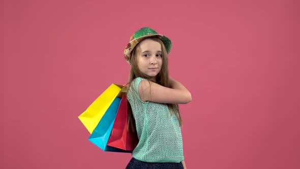 Girl Gets a Red Shoe From the Bag and She Is Happy . Pink Background. Slow Motion