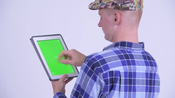 Rear View of Young Hipster Man Using Digital Tablet