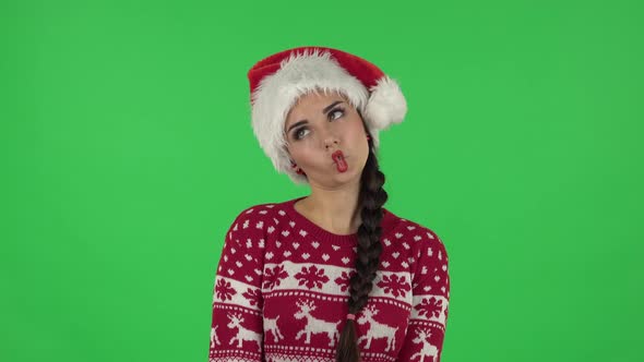 Portrait of Sweety Girl in Santa Claus Hat Is Making Funny Faces, Green Screen