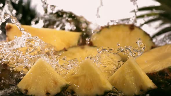 Slow Motion Shot of Pineapple and Water Splashing Through Pineapple Slices