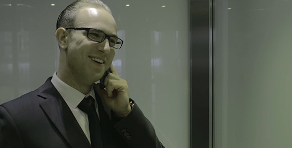Businessman Talking On Phone In Elevator