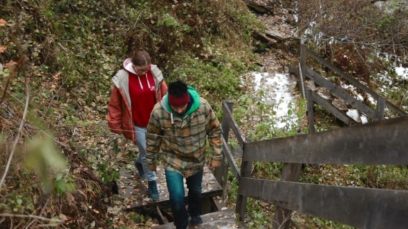 Couple Walking By The Waterfall