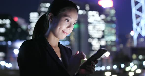 Woman Using cellphone with the background of Hong Kong city 