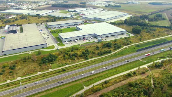 Aerial view of logistics center, warehouses near the highway. Delivery center Traffic