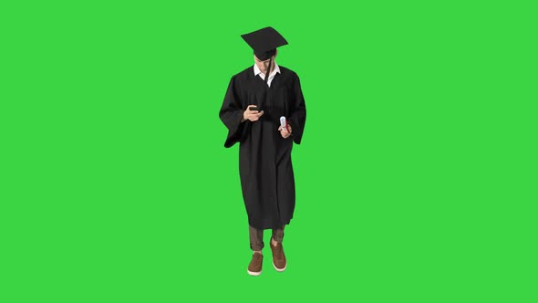 Smiling Student Walking and Texting on His Phone on a Green Screen, Chroma Key.