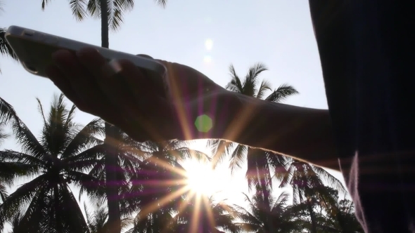 Hand Holding Smart Phone Against The Sun