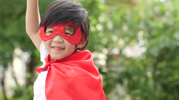 Asian Child In In Superhero Costume Playing In The Park