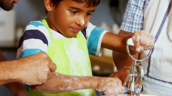 Multi-generation family preparing dessert in kitchen