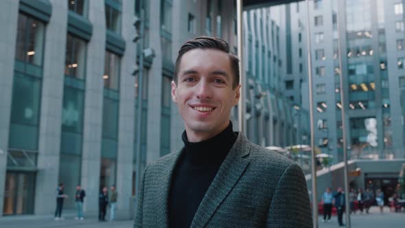 Portrait of Smiling Business Man in Suit Looking Into Camera Outdoors at City Downtown. Handsome