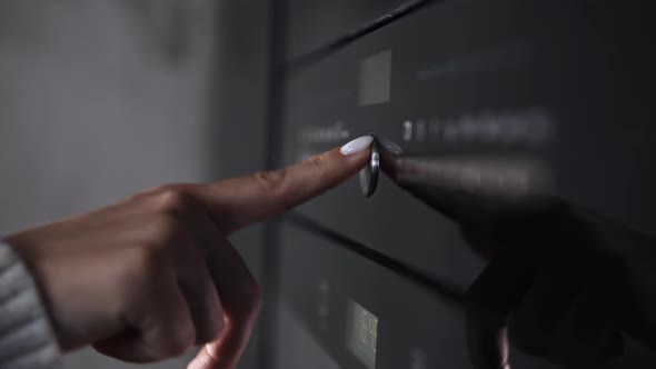 Female Finger Presses a Button on Modern Gas Stove or Oven. Woman Cooking Dinner