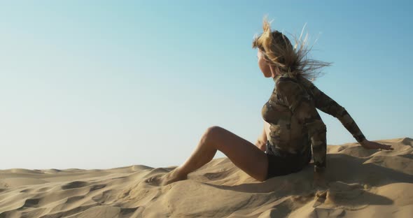Sexy Woman in Black Shorts is Dancing in the Desert Getting Up Walking