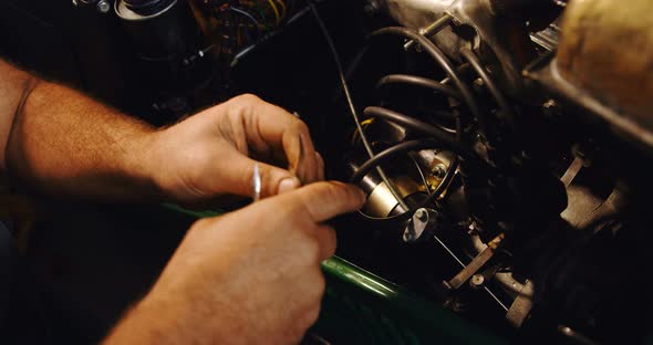 Male mechanic servicing a car in garage 
