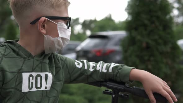 A boy in a protective mask stands near the house.