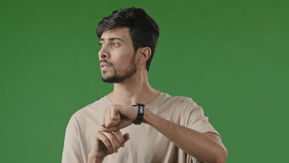 Portrait of Serious Impatient Arabian Man Guy Waiting for Meeting Over Green Background Looking at