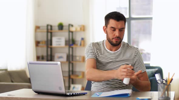 Man Using Hand Sanitizer at Home Office