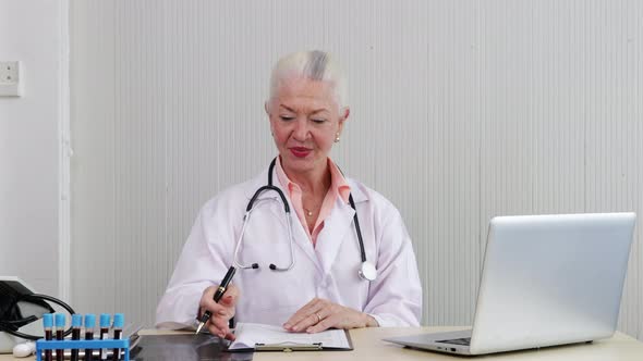 Senior Female doctor checking the symptoms of the woman patient.