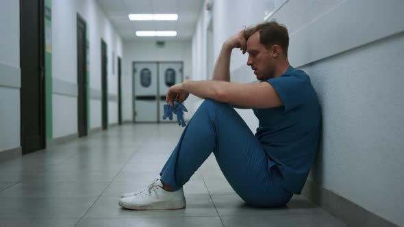 Stressed Surgeon Staying Clinic Hallway After Operation