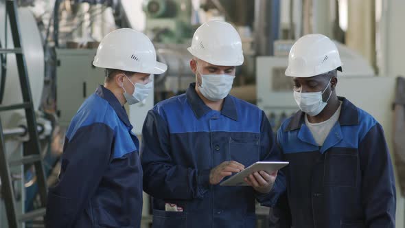  Slowmo of Plant Workers with Tablet Talking