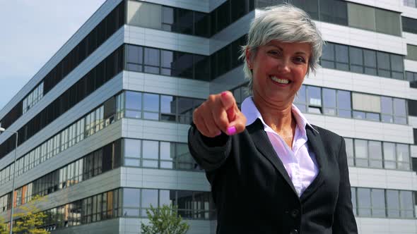 Business Middle Age Woman Points To Camera with Finger and Chooses Someone