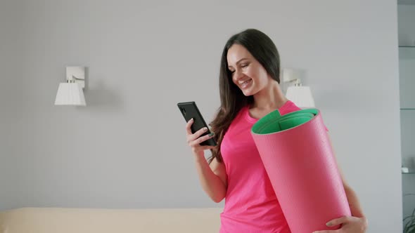 Cheerful Young Woman Holds Yoga Mat Her Hand Talks Phone