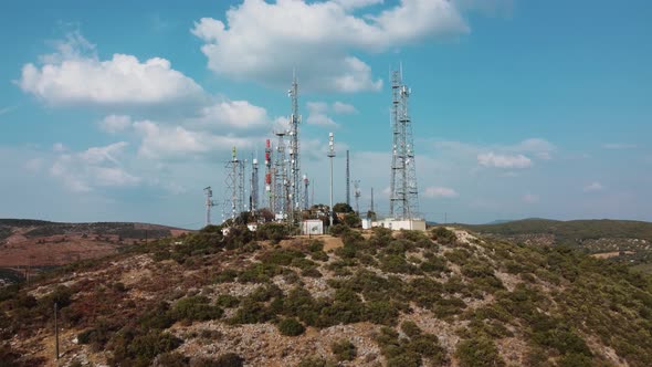 Aerial view of telecommunication communication towers on the mountain near the city.