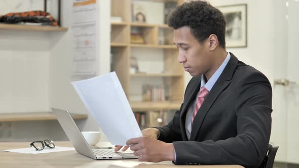 African Businessman Doing Paperwork in Office