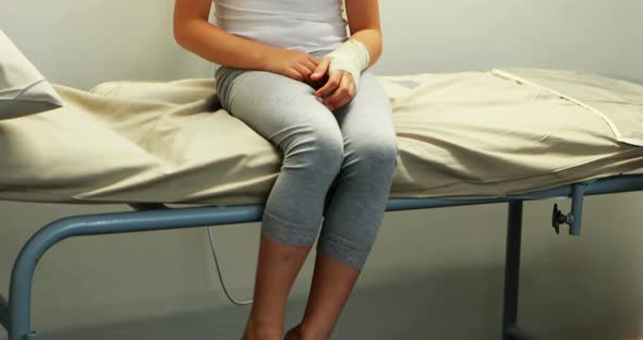 Injured girl sitting on stretcher bed