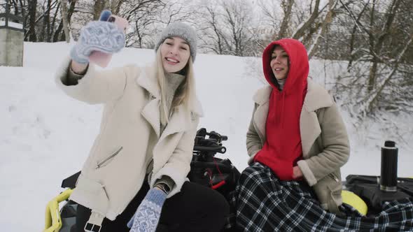 Two Young Women Posing with ATV Quad Bike in Winter Forest