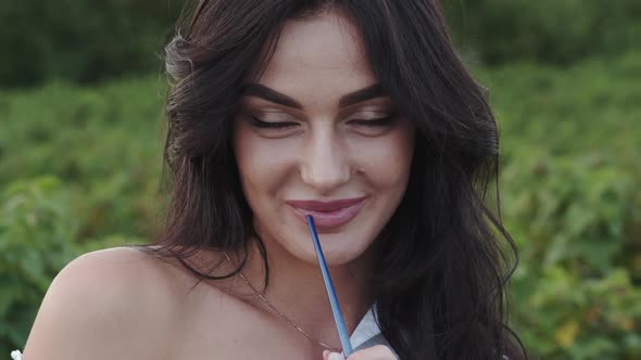 Portrait of Passionate Brunette with Brush in Hand Gazing at Camera and Flirting