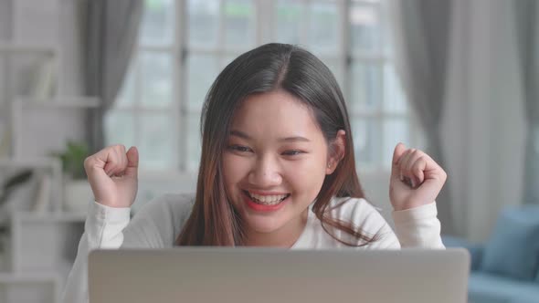 Excited Asian Young Girl Working On Laptop Computer At Desk