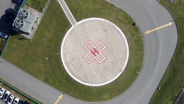 Aerial Overhead View of a Helipad at a Hospital, Drone Rising Spin Shot on a Sunny Day