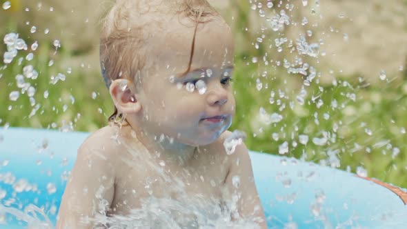 Cute Little Child Bathing in Blue Street Pool in Courtyard. Portrait of Joyful Toddler, Baby. Kid