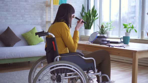 Young Disabled Girl in a Wheelchair Pulls Up To the Table and Does Makeup