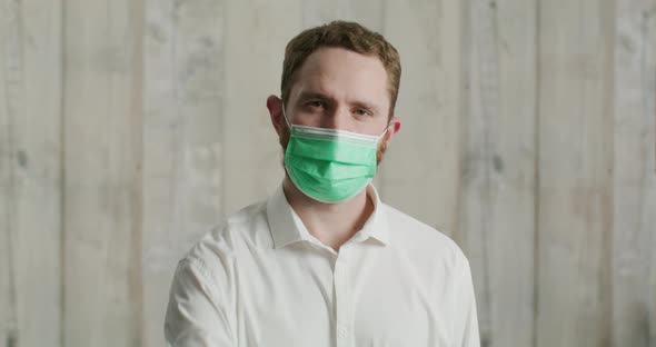 Man in a White Shirt Wears a Medical Mask and Shows Colorful Medical Masks