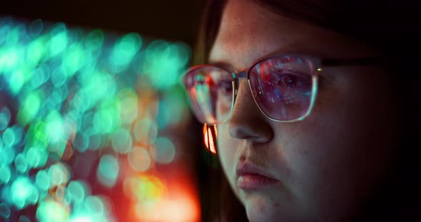 Closeup of Young Adult Female Wearing Reflective Eye Glasses Analyzing Cyber Security Code Data Work