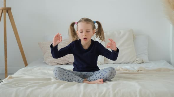 Little Girl Meditating in Lotus Position Indoors