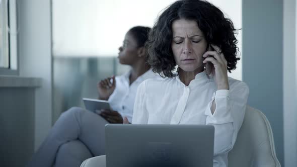 Serious Businesswoman with Laptop and Smartphone